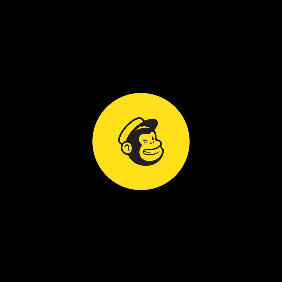 Yellow circle with a cartoon smiling man with a beard and cap in the center, set against a black background.