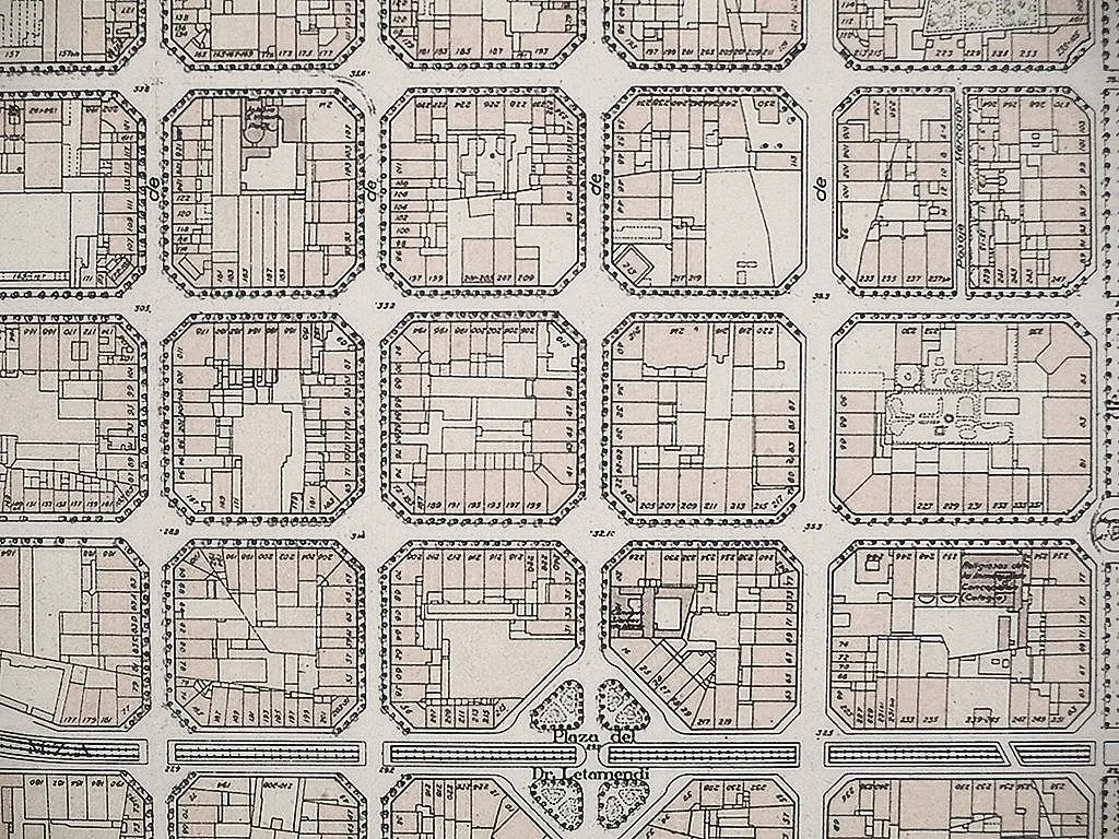 Plano de una urbanización o colonia con calles y lotes, algunos con detalles como casas o áreas verdes.