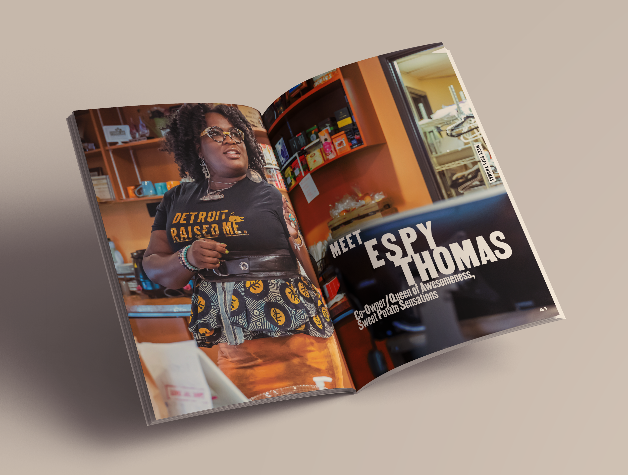 Magazine spread featuring Espy Thomas, co-owner of Sweet Potato Sensations, wearing a black "Detroit Raised Me" T-shirt and colorful skirt, standing in a kitchen or cafe with shelves of dishes and a refrigerator in the background.