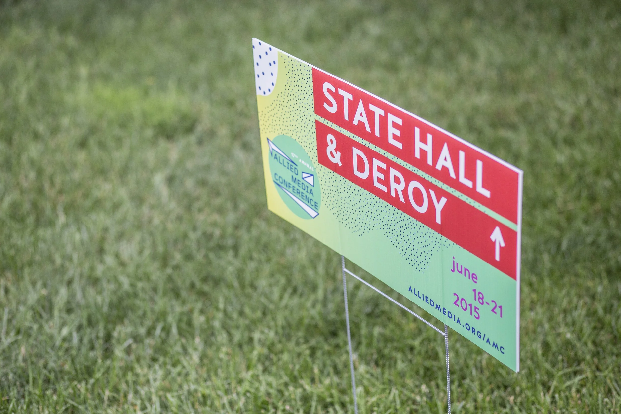 Sign for the State HALL & Deroy at the Allied Media Conference, June 18-21, 2015, on green grass.