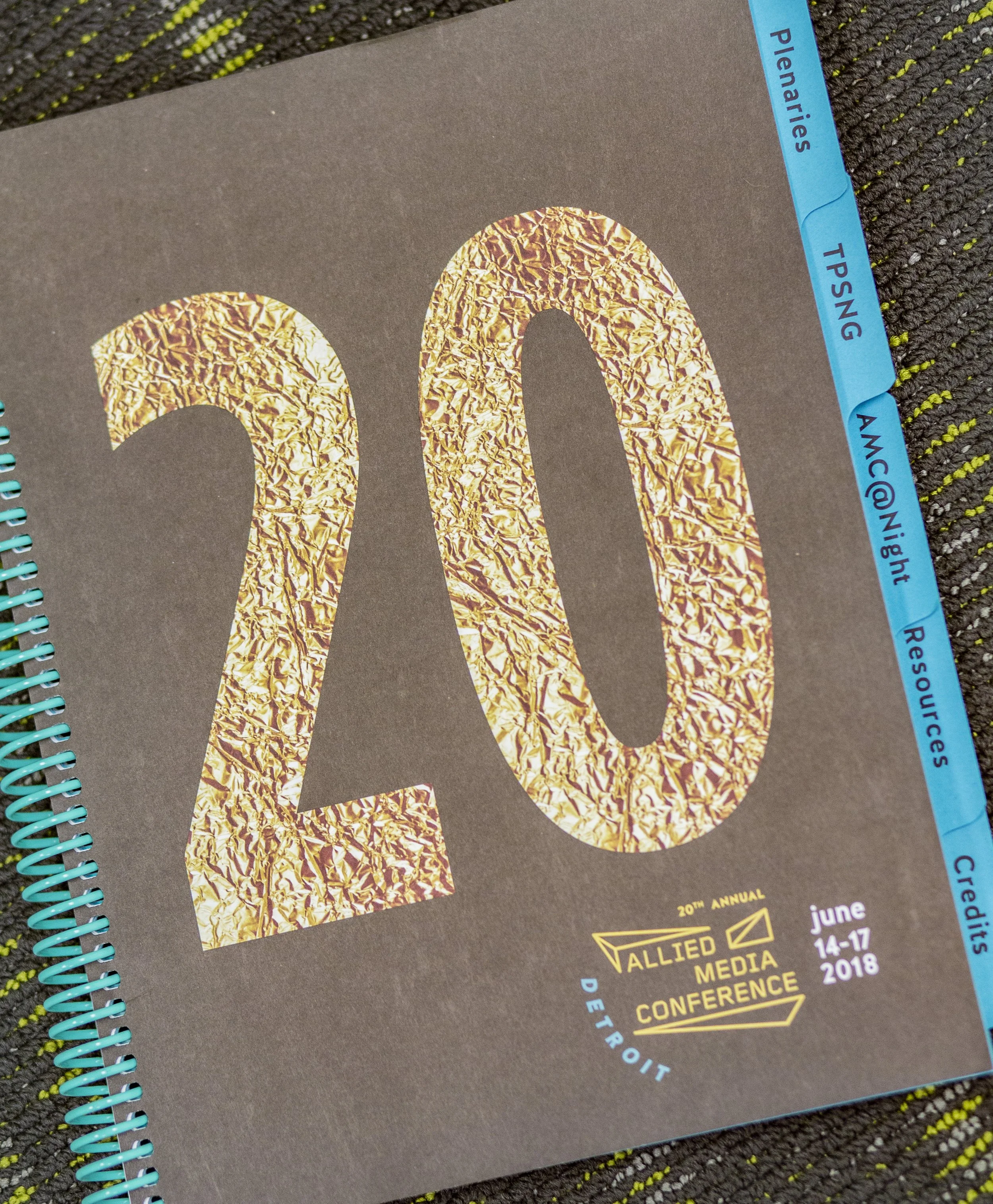 Cover of a conference booklet with large number 20 made of crumpled gold foil, indicating the 20th Annual Allied Media Conference, held June 14-17, 2018, in Detroit.