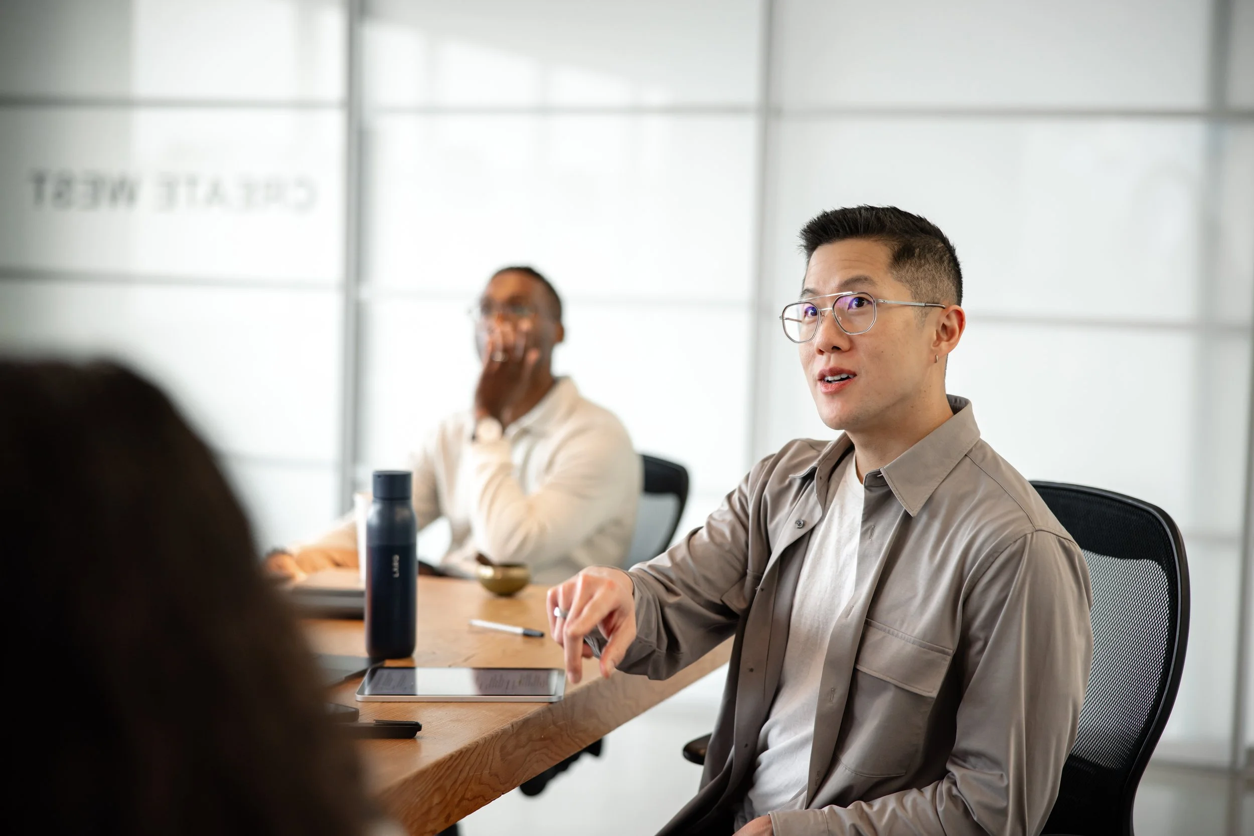A male employee engages in a experiential leadership training in a conference room with his team and consultants