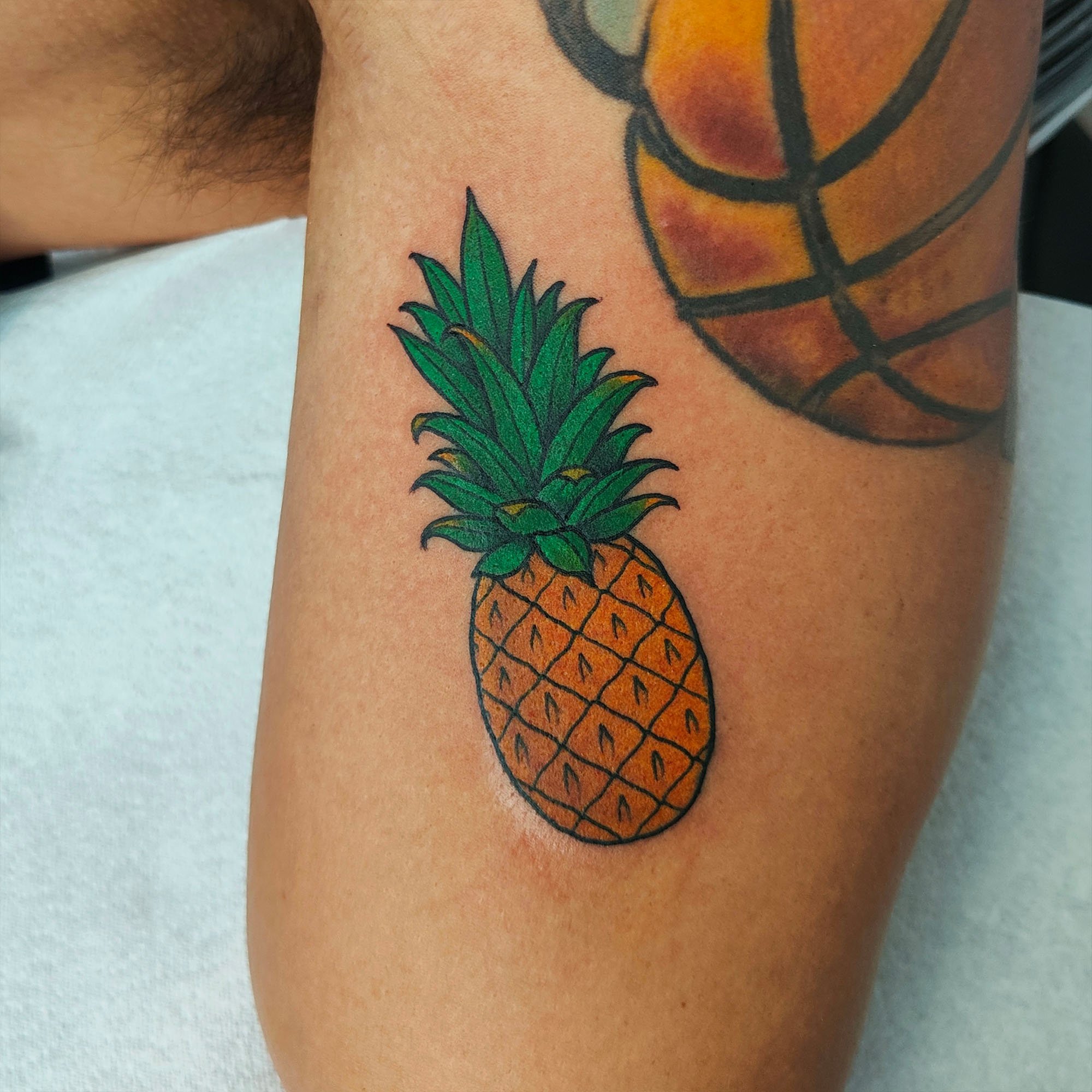 Tattoo of a pineapple on a person's skin