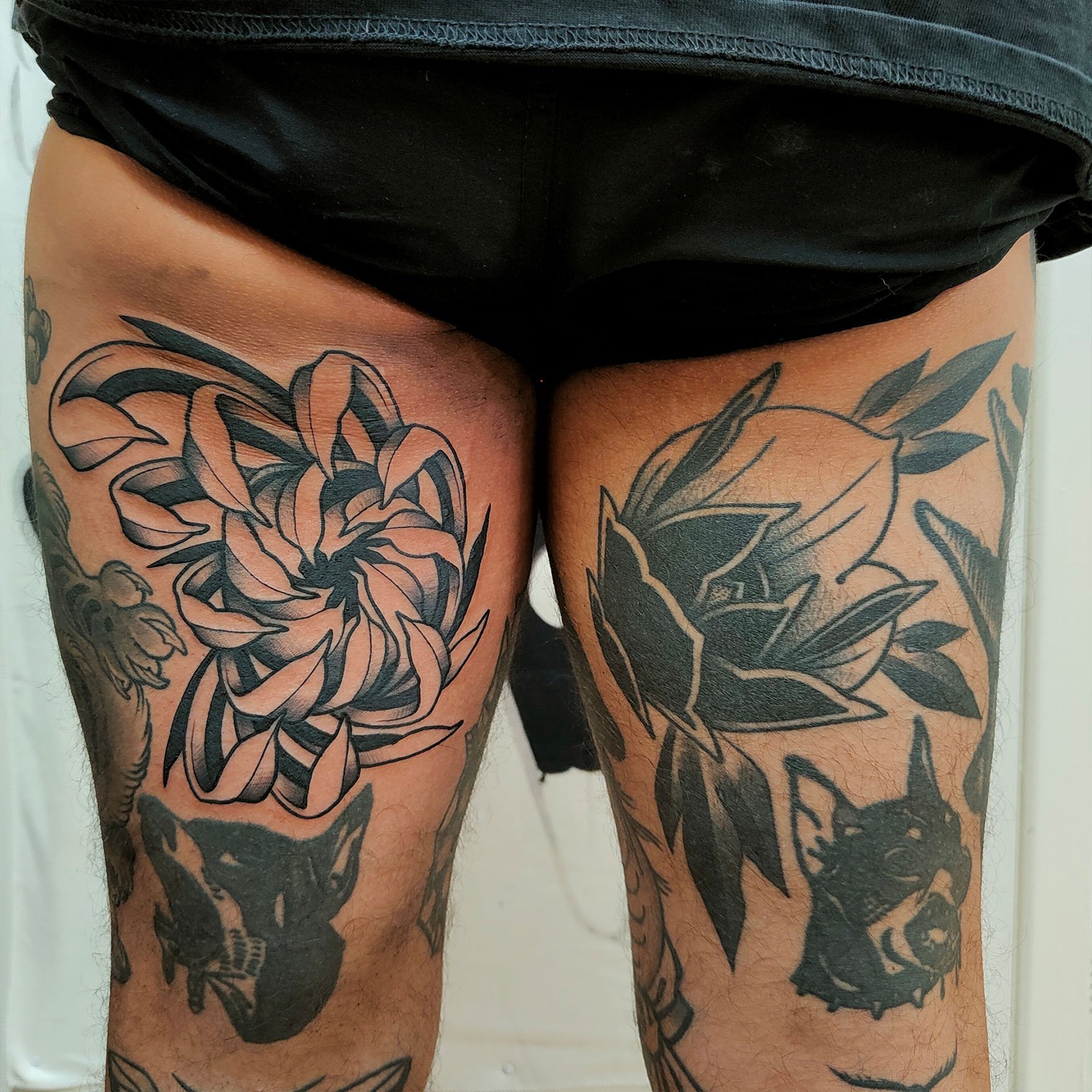 Tattoos of flowers and animals on thighs