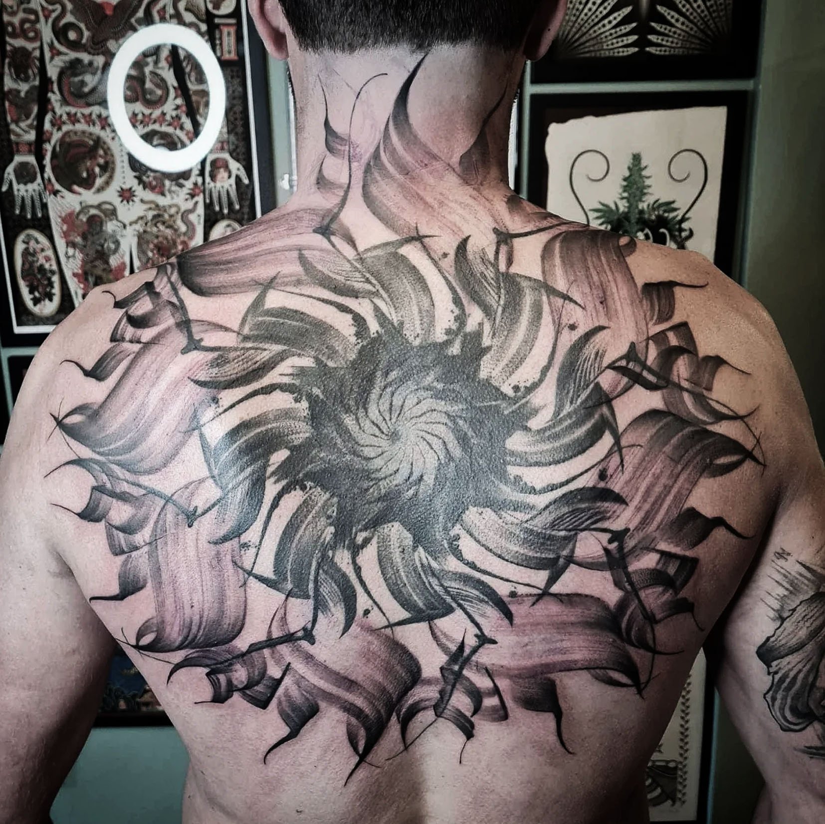 Abstract back tattoo with swirling design and bold strokes