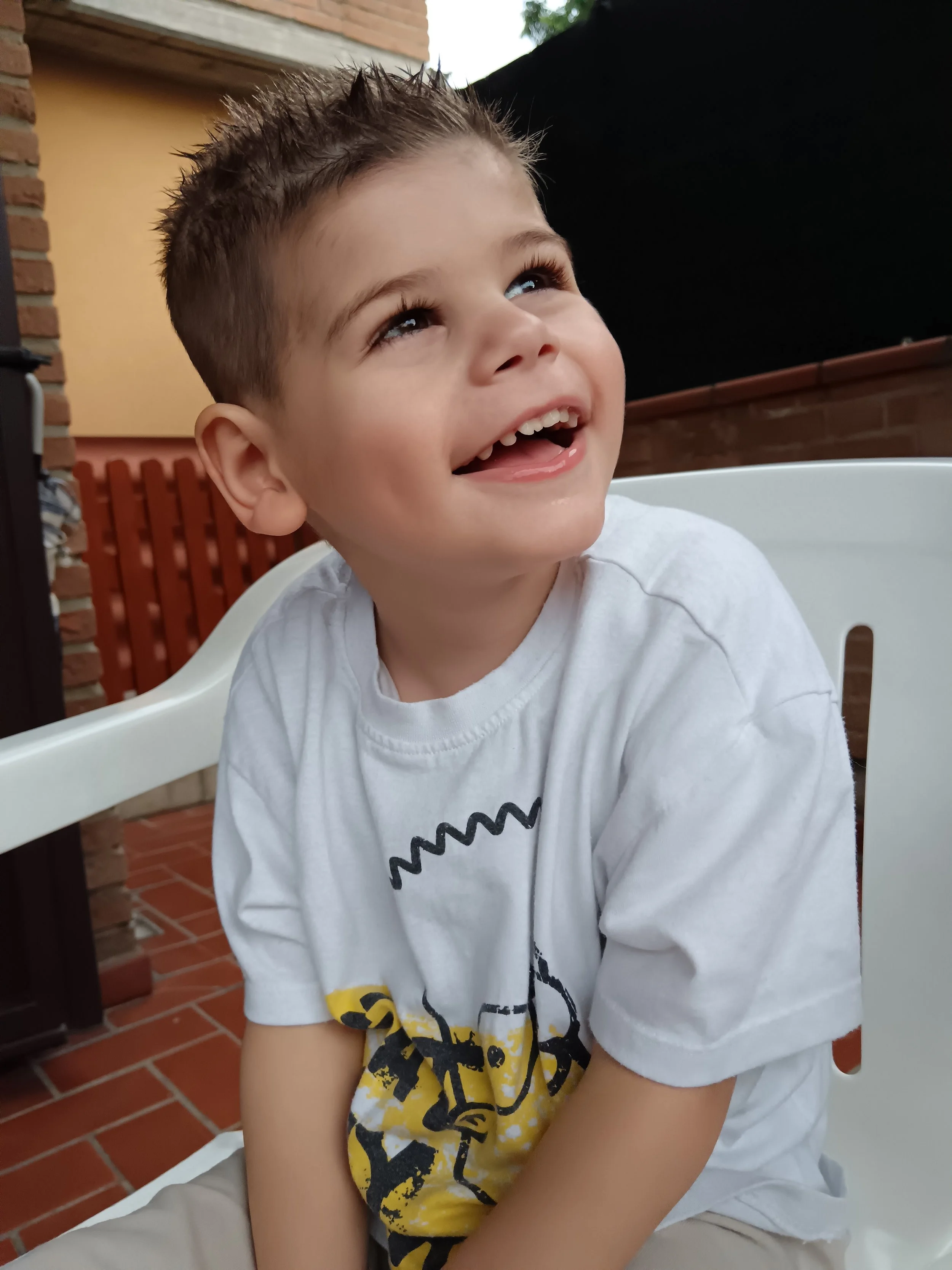 A picture of a little boy, Gabriel sat on a white chair - Gabriel has NARS1 Disorder