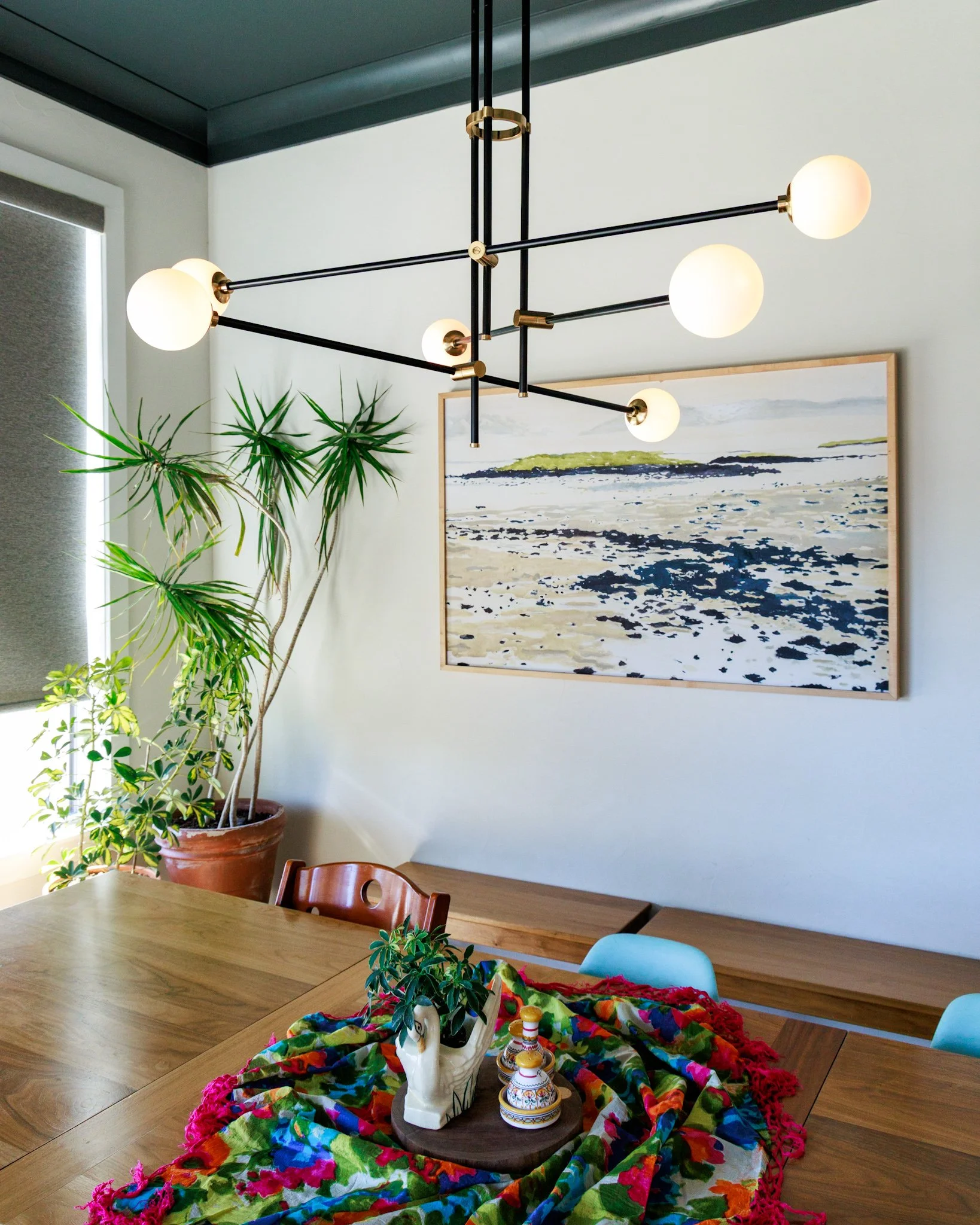 breakfast nook dining area with painted ceiling, modern chandelier, and custom wood dining table in Argyle Texas
