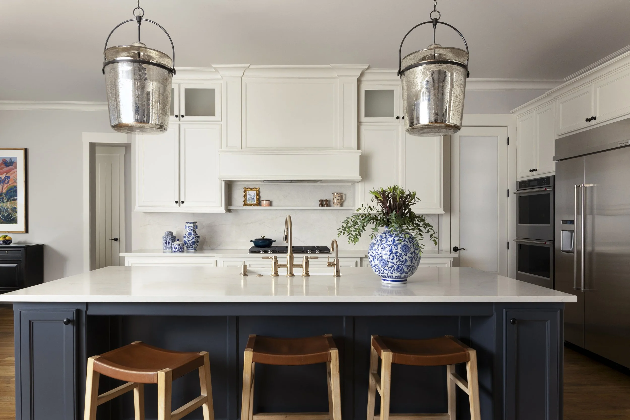 Existing cabinetry refreshed with a painted blue island, new countertops, and a full-height backsplash in a Dallas-Fort Worth area home.