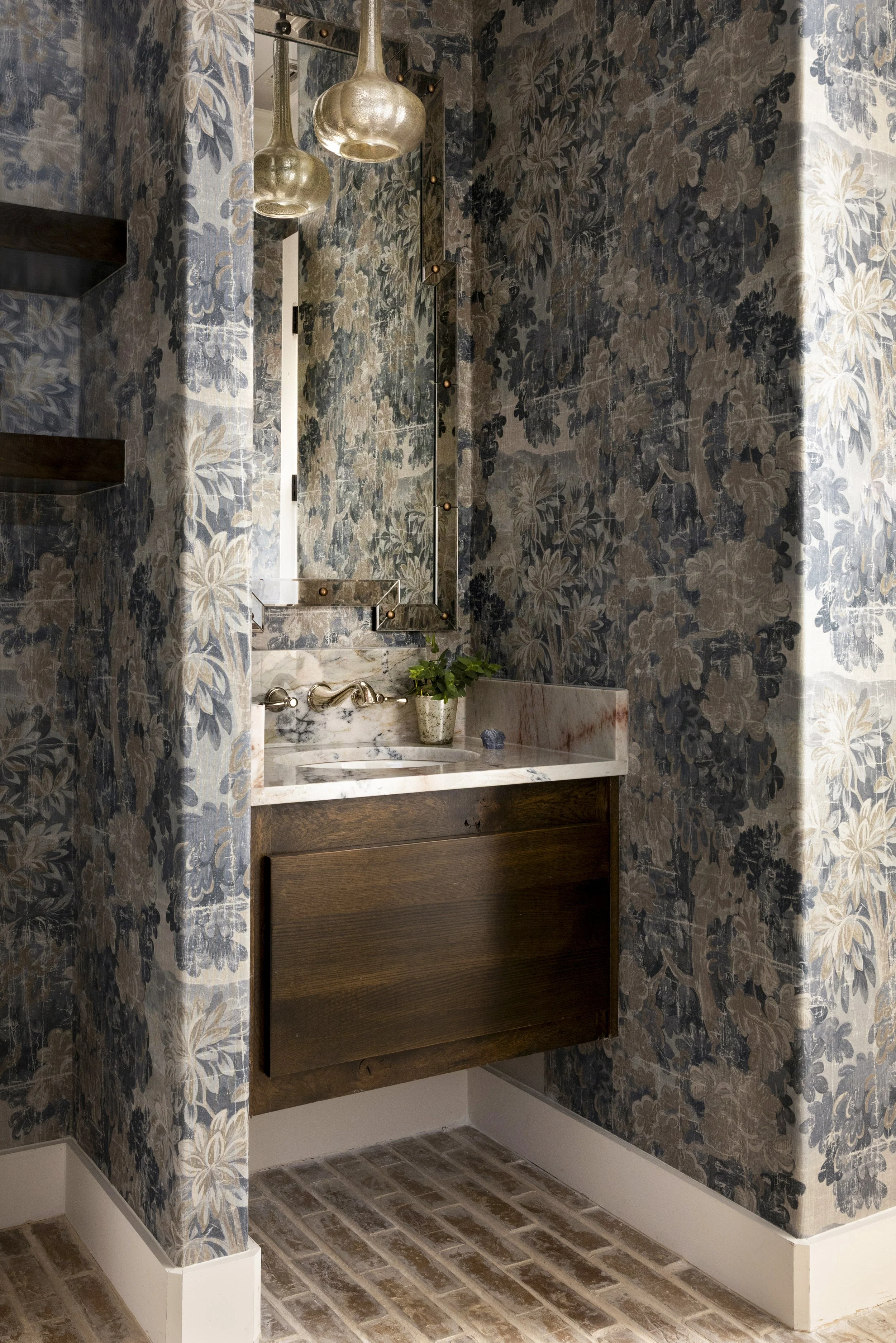 Bold wallpaper, warm wood, and marble create a memorable powder room in a Dallas-Fort Worth area home.