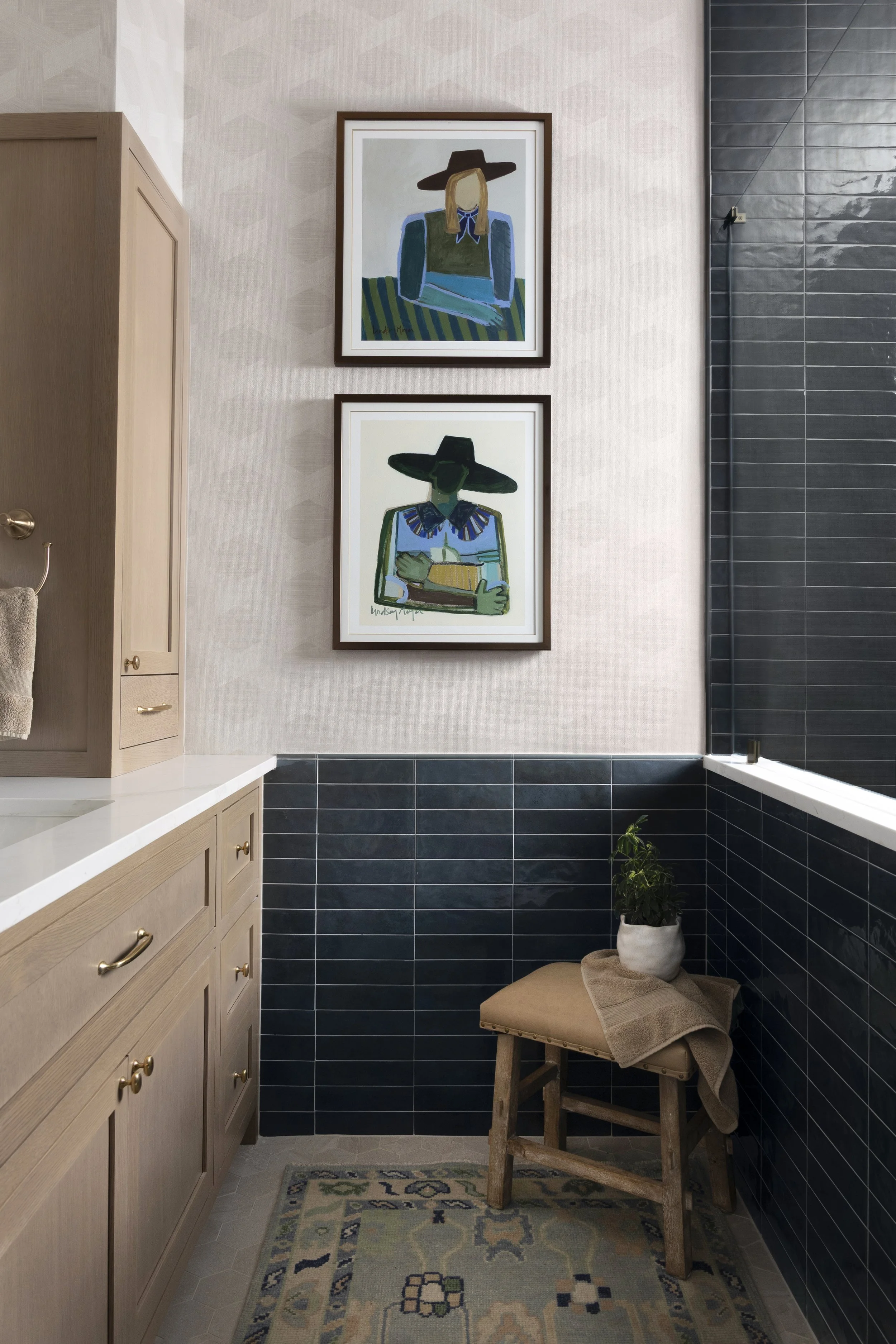 Primary bathroom with bold blue statement tile, custom artwork, designer wallpaper, and a glass shower enclosure, creating a timeless yet collected design in the Dallas-Fort Worth area.