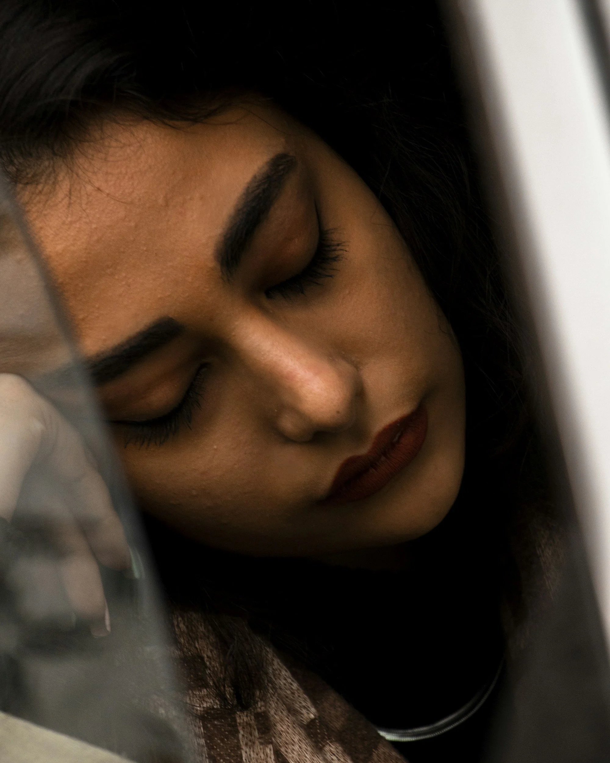 Exhausted woman leans her head on her hand.
