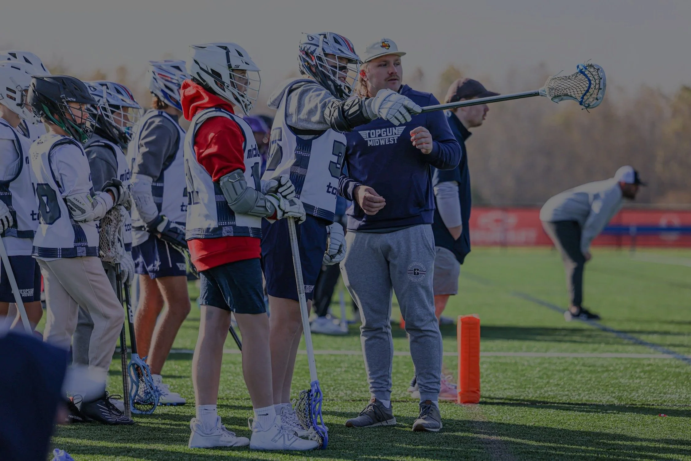 Lacrosse players and coach on the field during practice or game