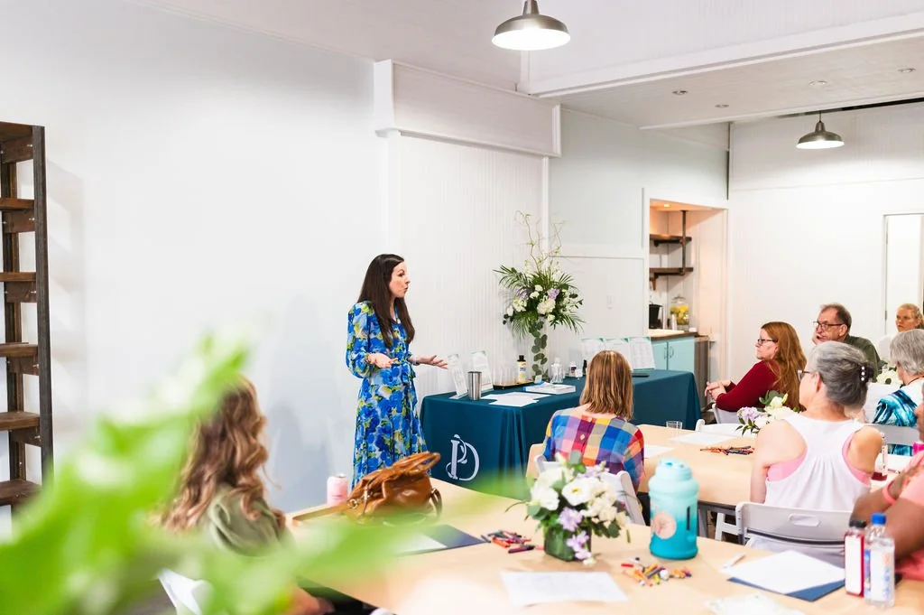A Christian Counselor in a colorful dress presents to a group of people who desire peace and healing.