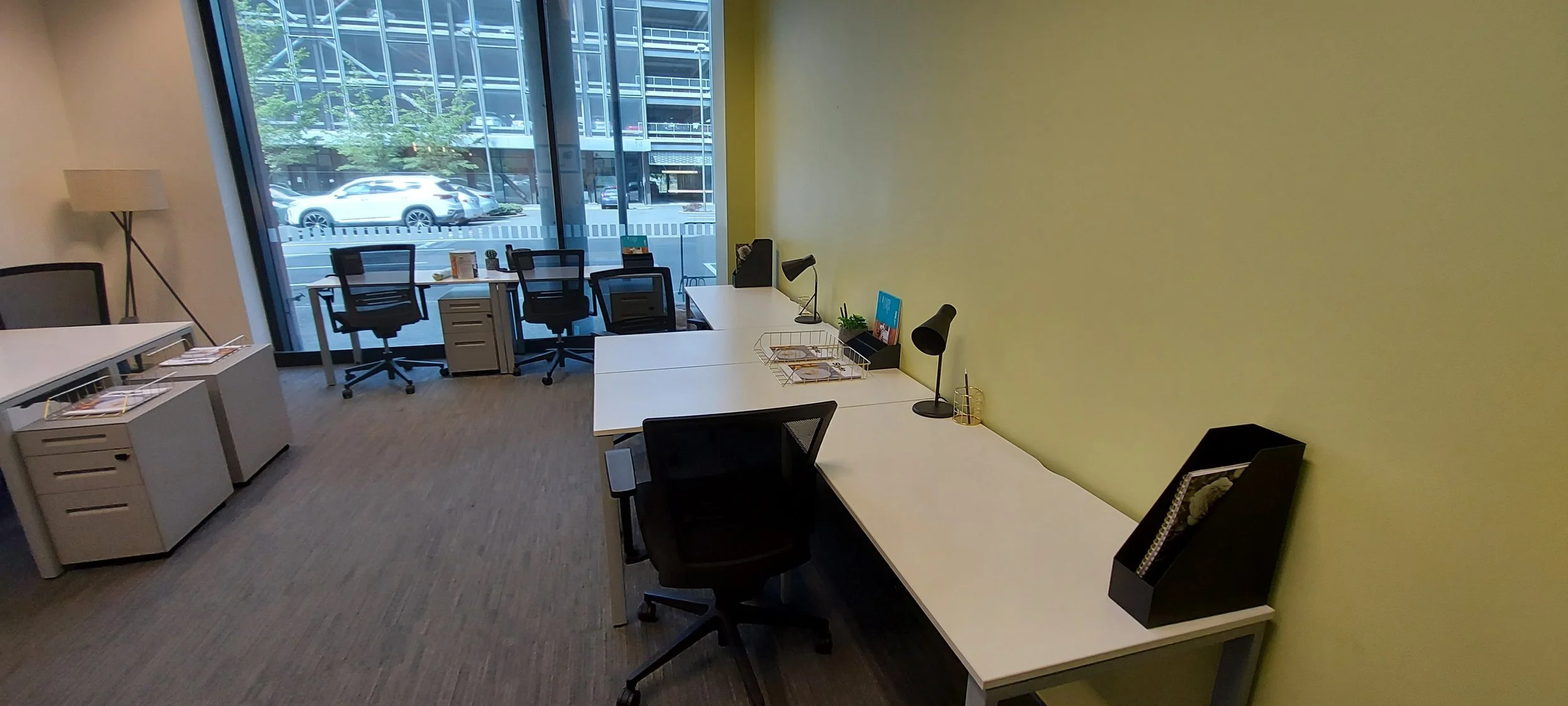 Completed painting of an office interior in Christchurch CBD with freshly painted yellow accent wall and modern workstations.