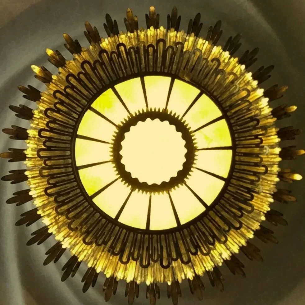 Artistic chandelier design with sunburst pattern and warm lighting