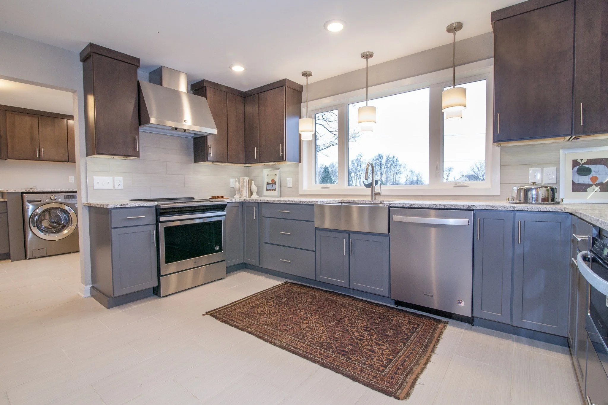 Modern kitchen remodel with gray cabinets, stainless appliances, pendant lights, and bright open design—blending function with timeless style.