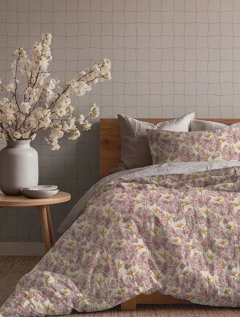 Estampa botânica autoral de Lívia Cruz com monotipia a partir de planta natural e desenho digital de estrelícia aplicada em roupa de cama