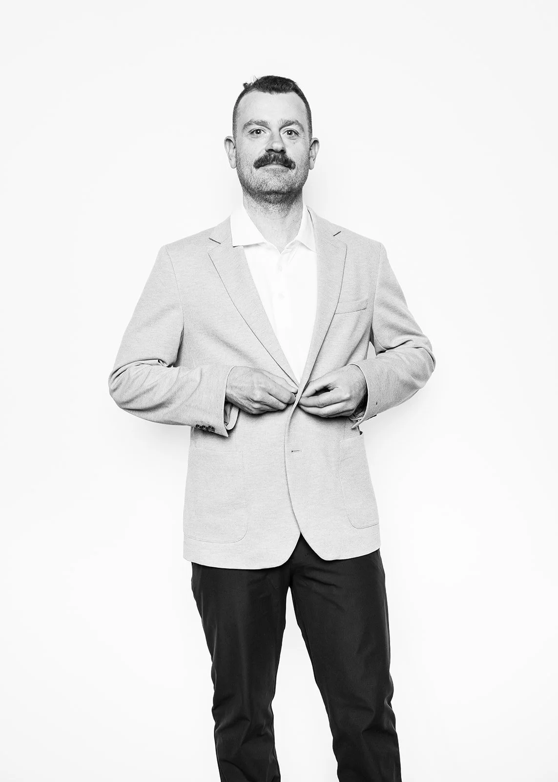 A man in a blue t-shirt and pink sneakers appears to be floating in a futuristic, digital environment filled with vibrant, glowing blue and pink light patterns and technological elements.
