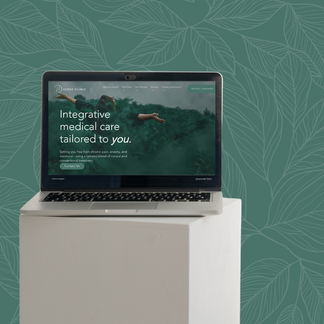 Laptop on a white stand displaying a healthcare website for Verde Clinic, with a background of green leafy pattern.