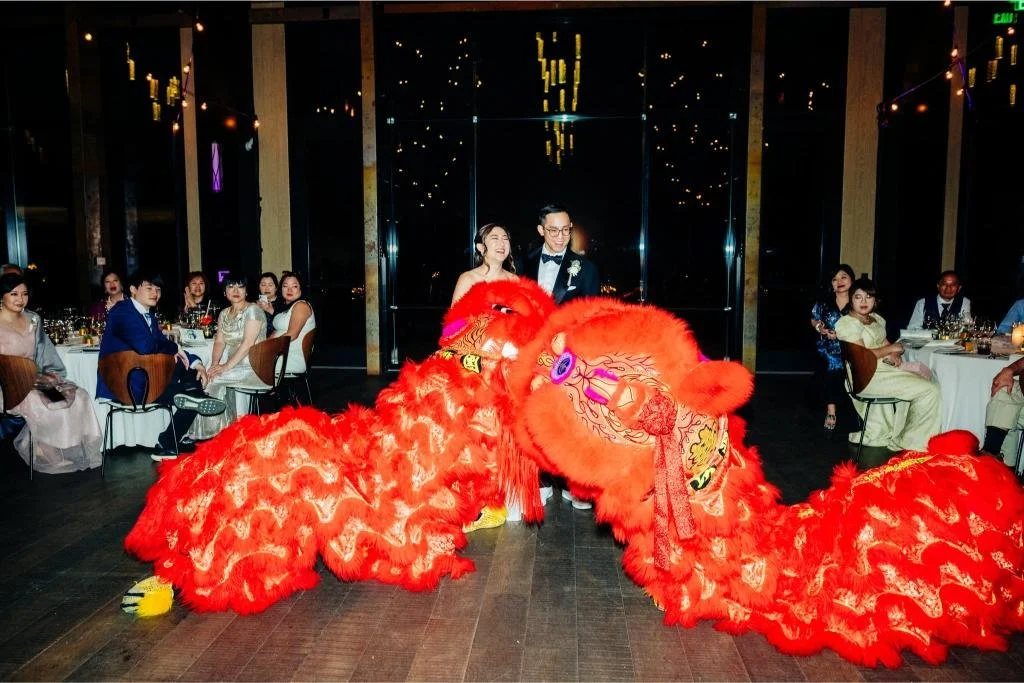 Two lion dance performers crossing the couple's path during the wedding reception