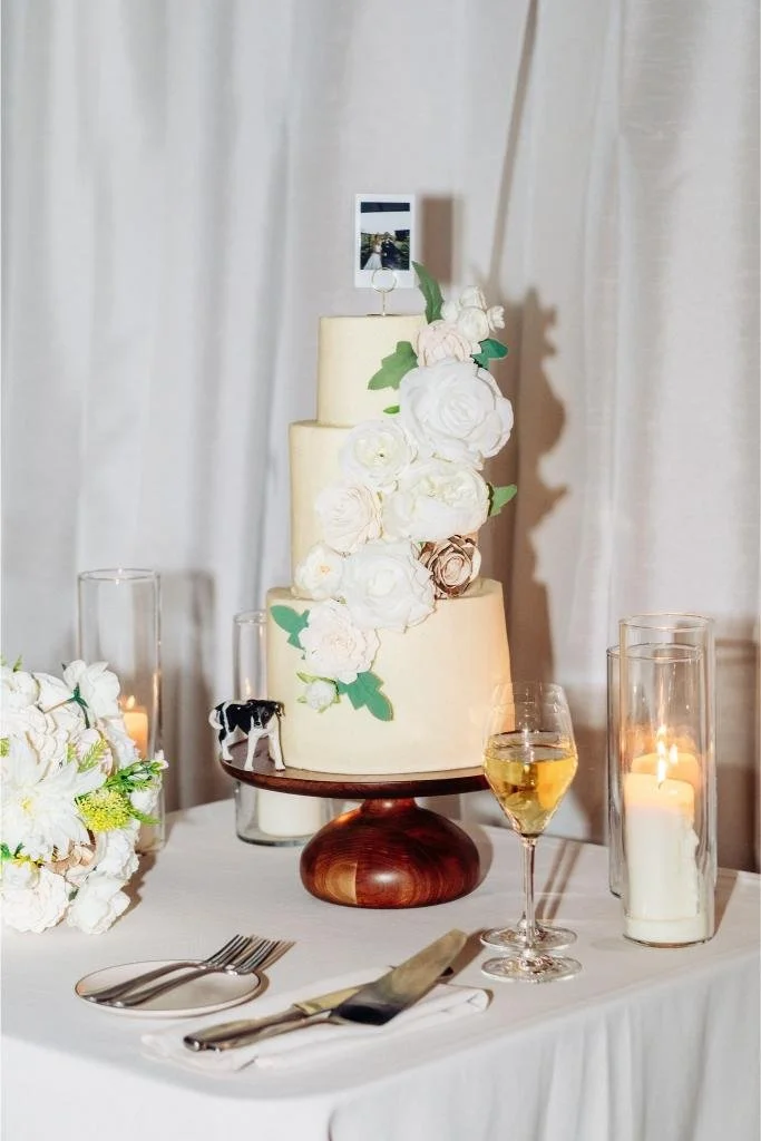 Wedding cake decorated with a dog figurine and a photo of the couple