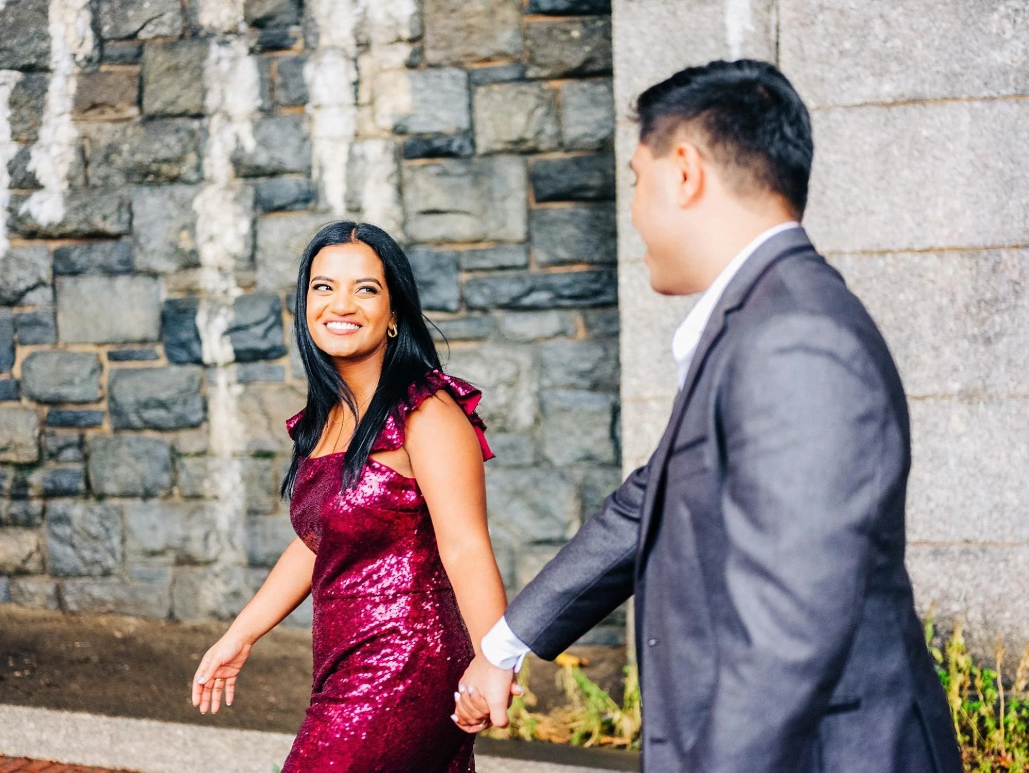Couple holding hands while walking through Fort Tryon Park during Upper Manhattan engagement session