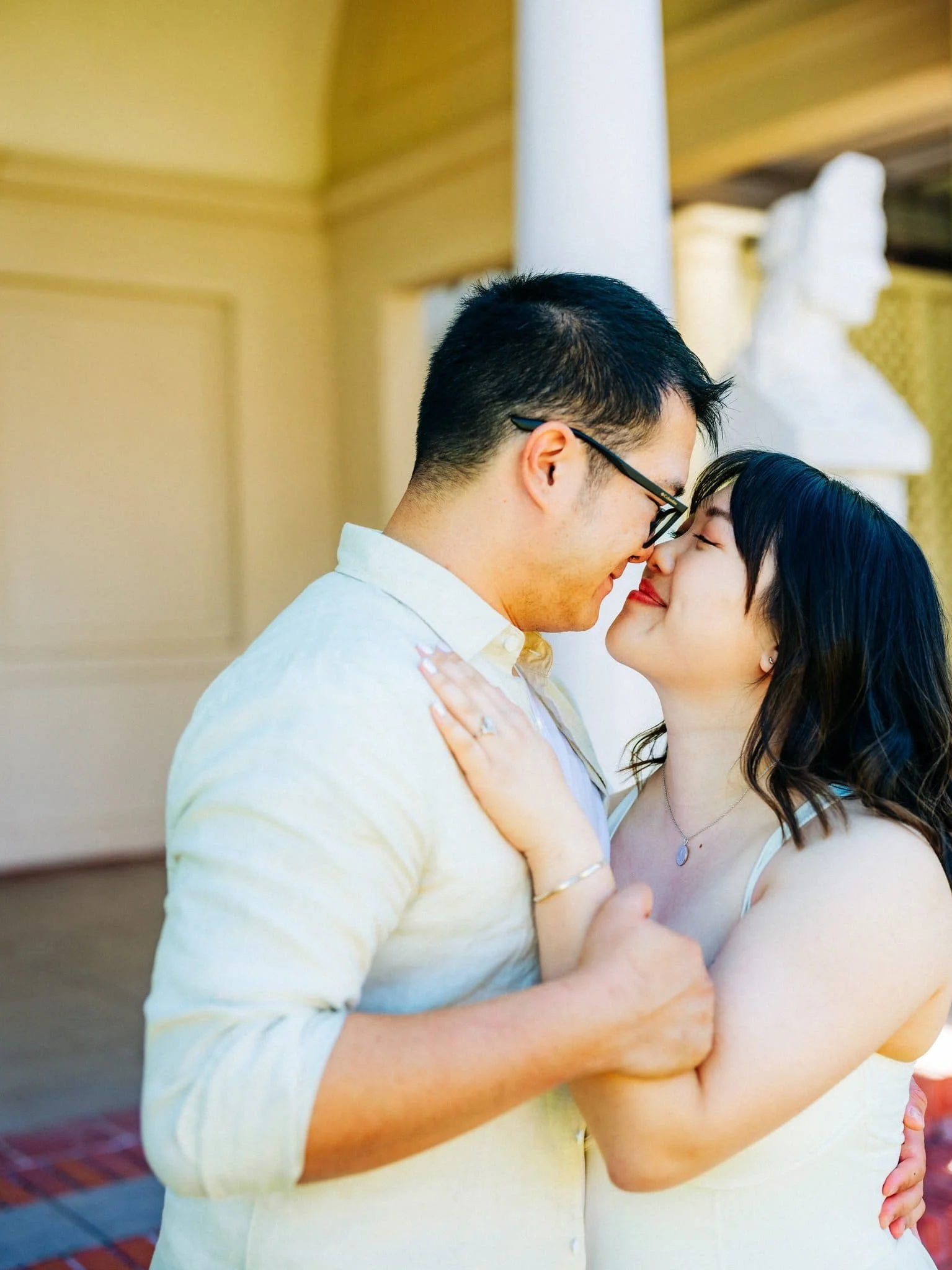Couple embracing during their Montalvo Arts Center engagement session in Saratoga, with her engagement ring visible.