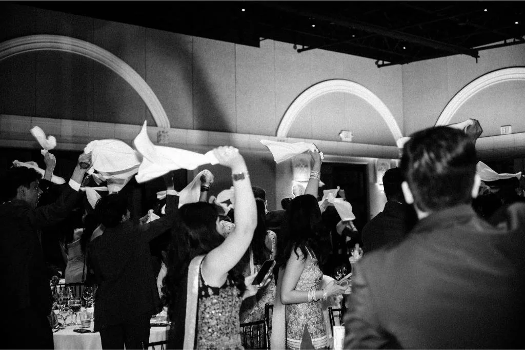 Wedding guests waving napkins overhead during the reception celebration