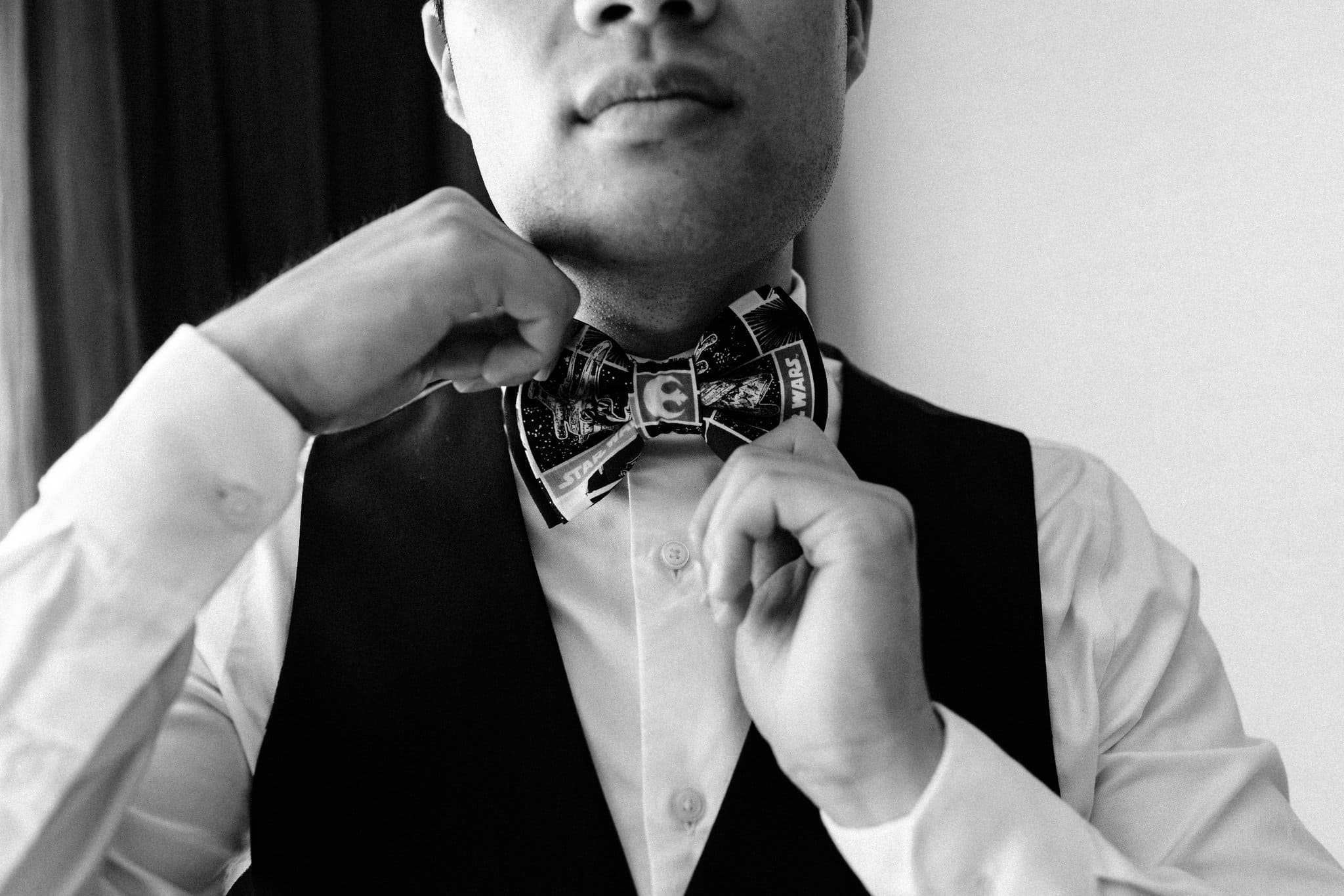 close up groom putting on bow tie getting ready palm event center pleasanton wedding