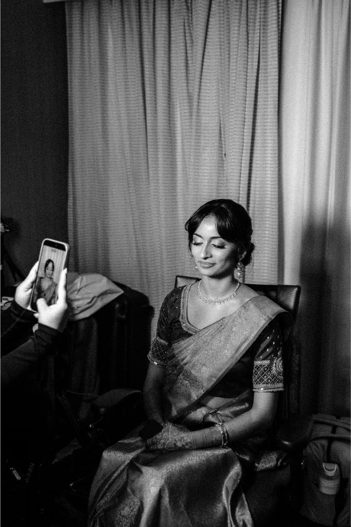 Bride smiling while getting ready before her Indian wedding ceremony