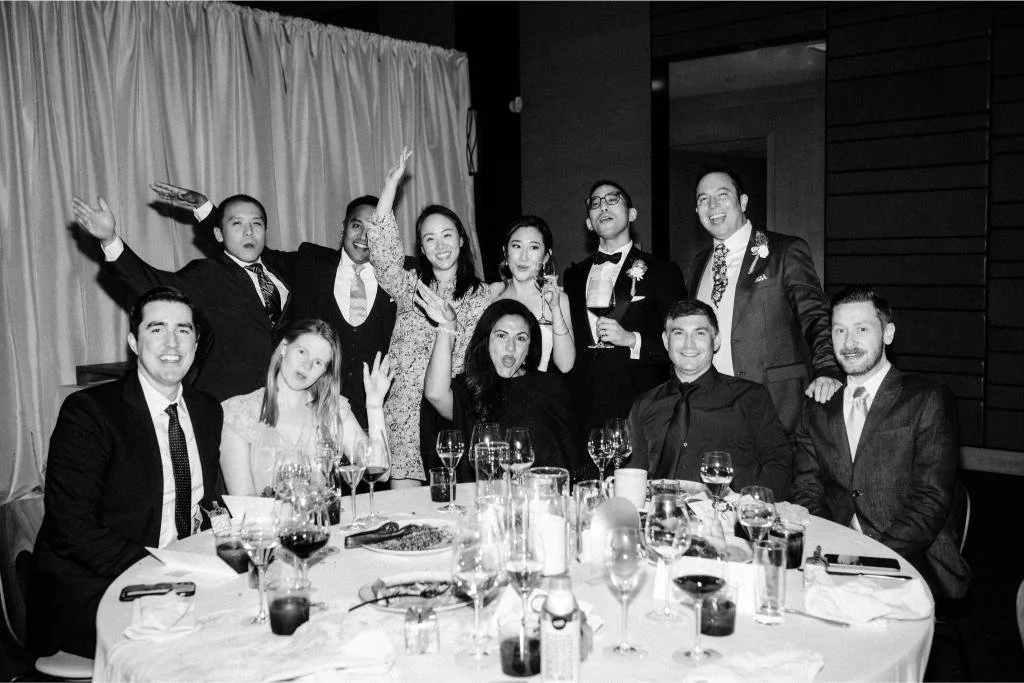 Wedding guests posing together at their table with wine glasses