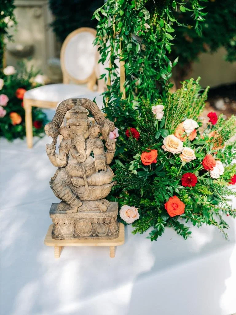 Decorative elephant statue displayed beside flowers at the Indian wedding