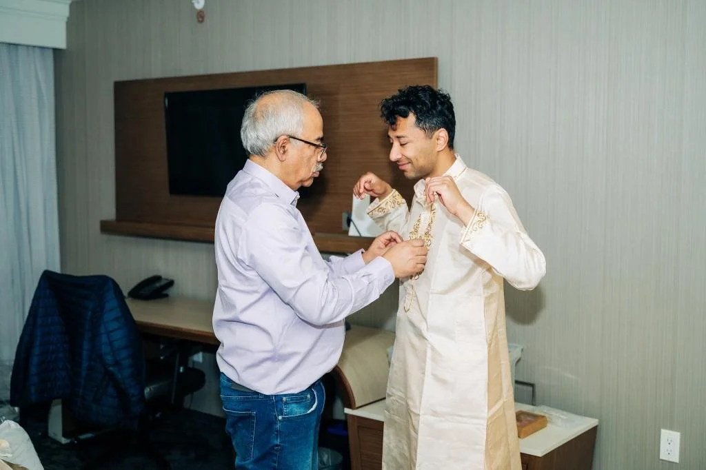 Groom getting ready with help from his father before the Indian wedding ceremony