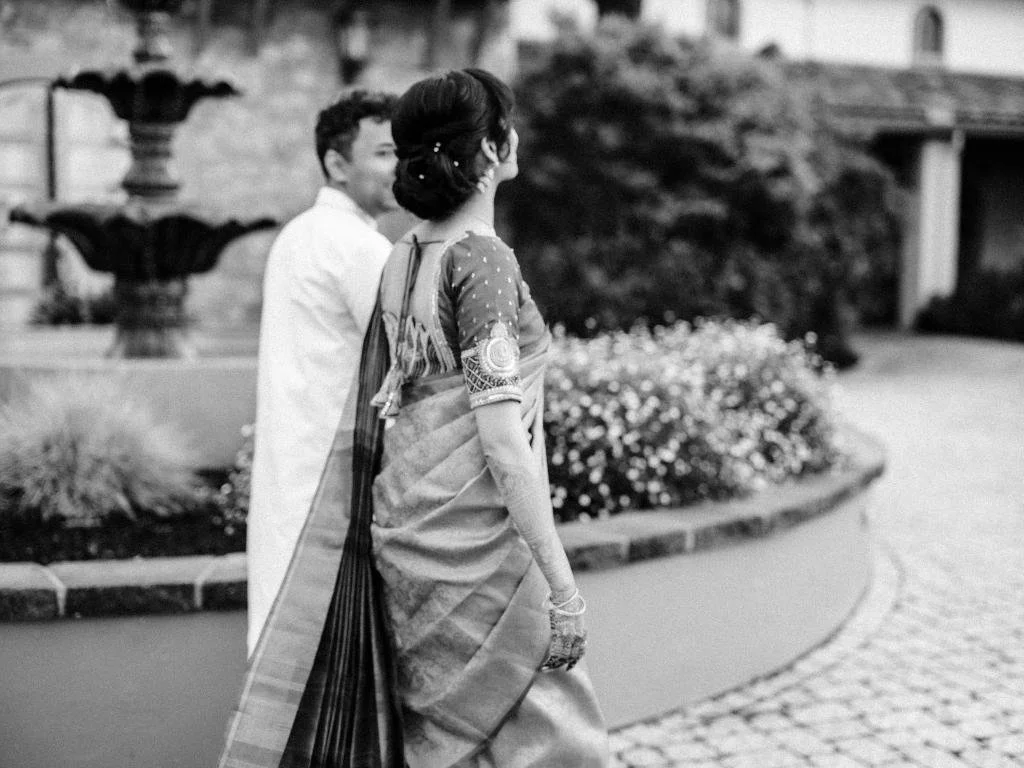 Bride and groom holding hands near a water fountain during portraits before the wedding