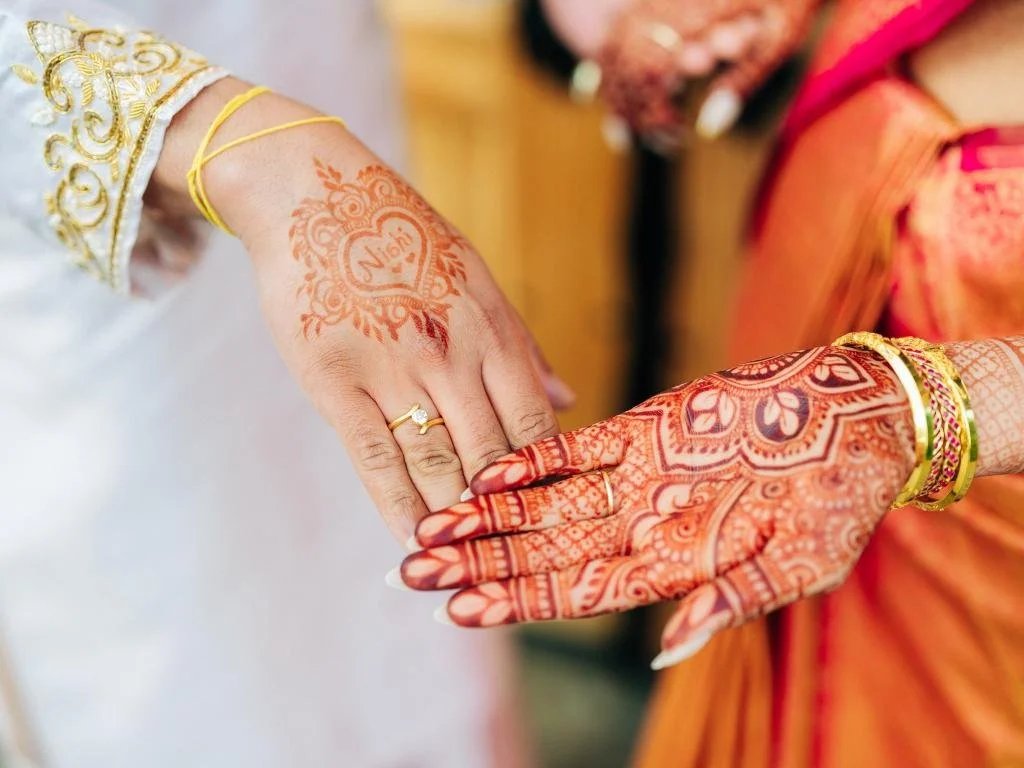 Close-up of the bride and bridesmaid showing their intricate mehndi henna designs