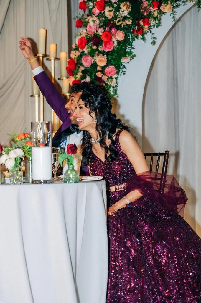 Bride and groom sitting together and laughing during a wedding reception speech