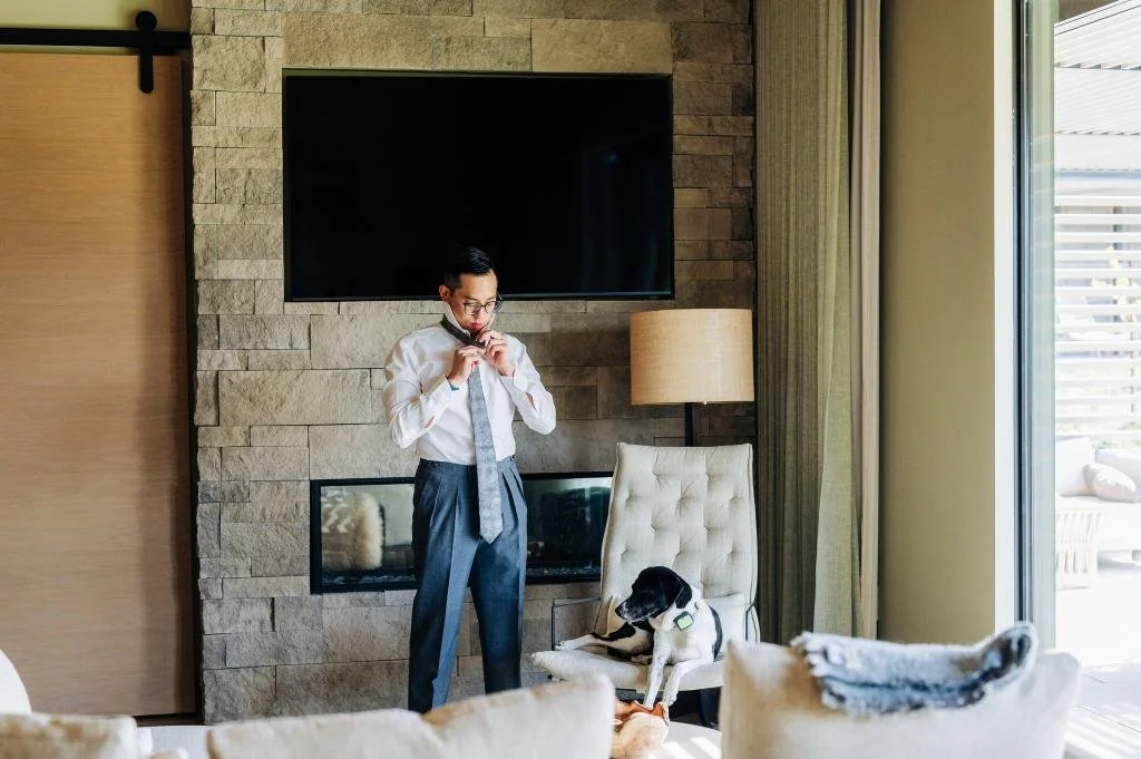 Groom adjusting his tie while getting ready for the wedding