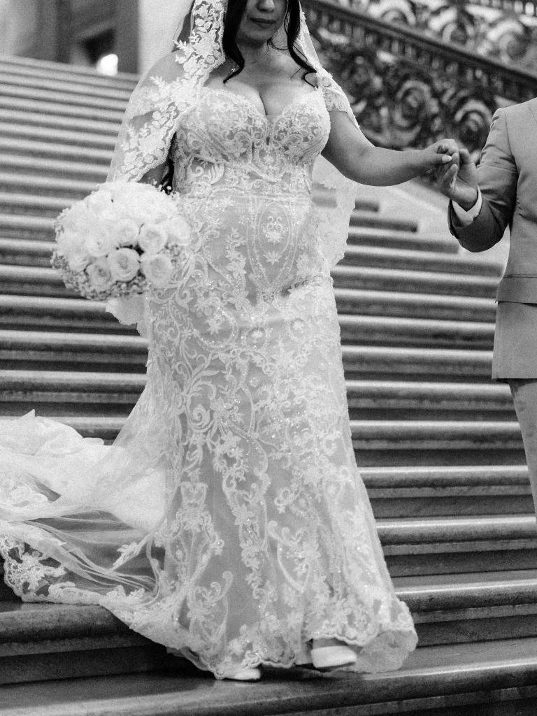 Bride walking down the stairs while holding the groom’s hand.