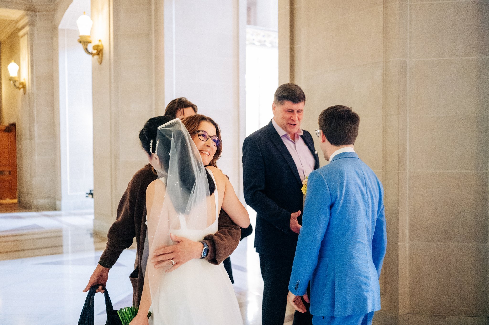 Bride and groom greeting their parents at San Francisco City Hall wedding