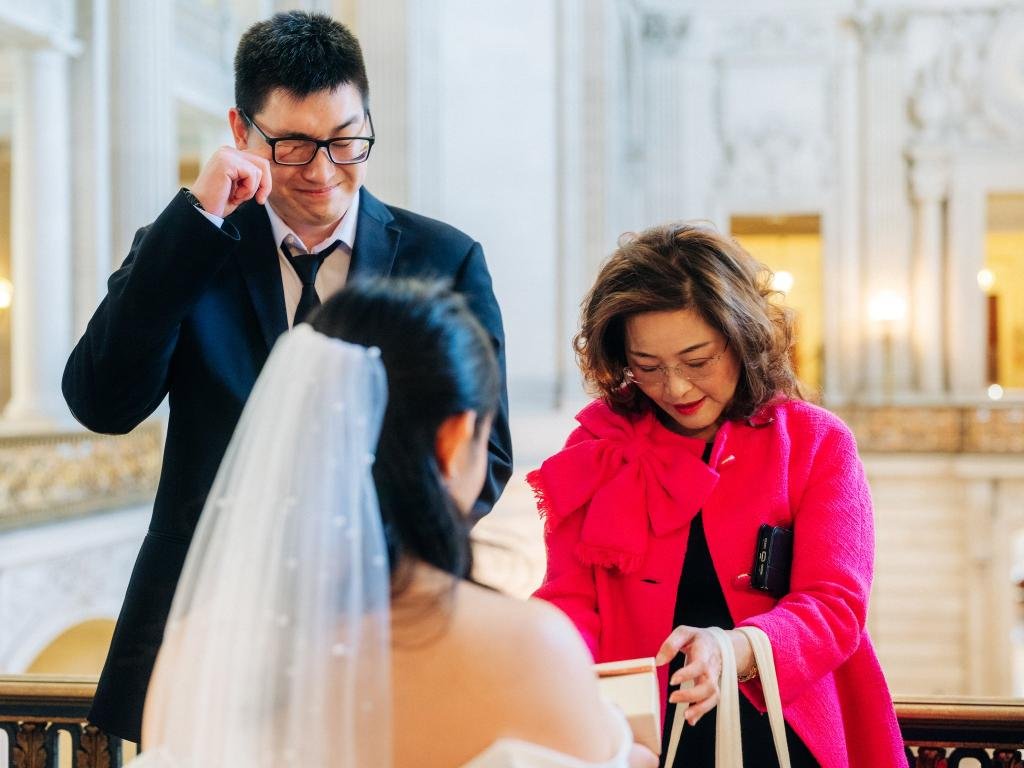 Groom wiping away tears during his San Francisco City Hall wedding ceremony