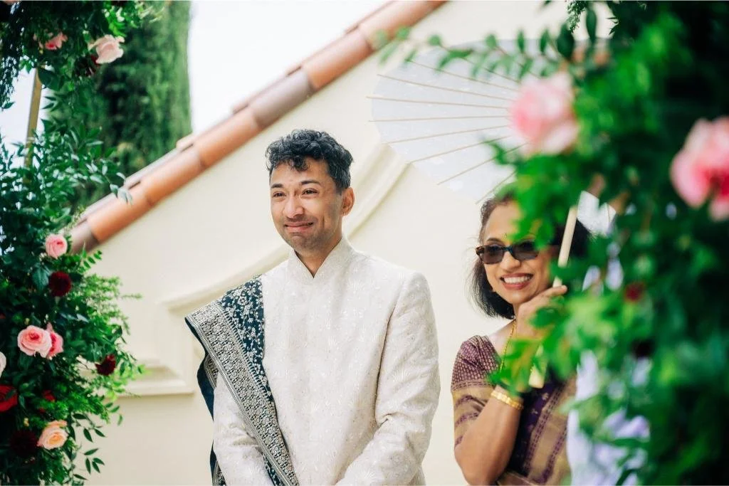 Groom smiling as the bride walks down the aisle during the ceremony