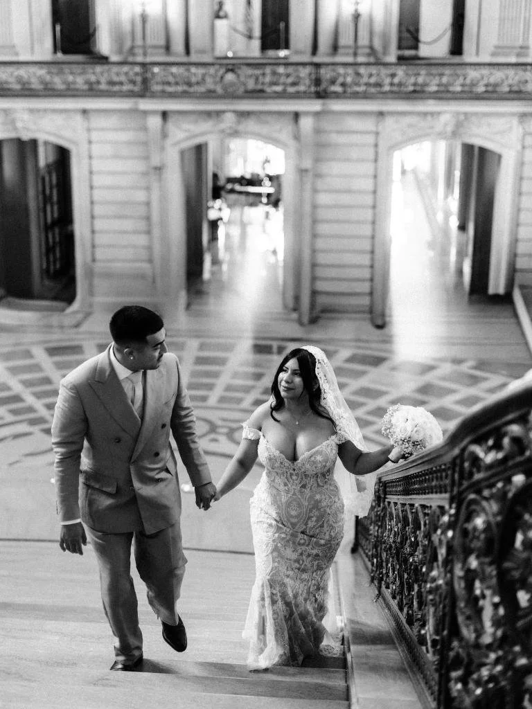 Bride and groom walking side by side up the Grand Staircase.