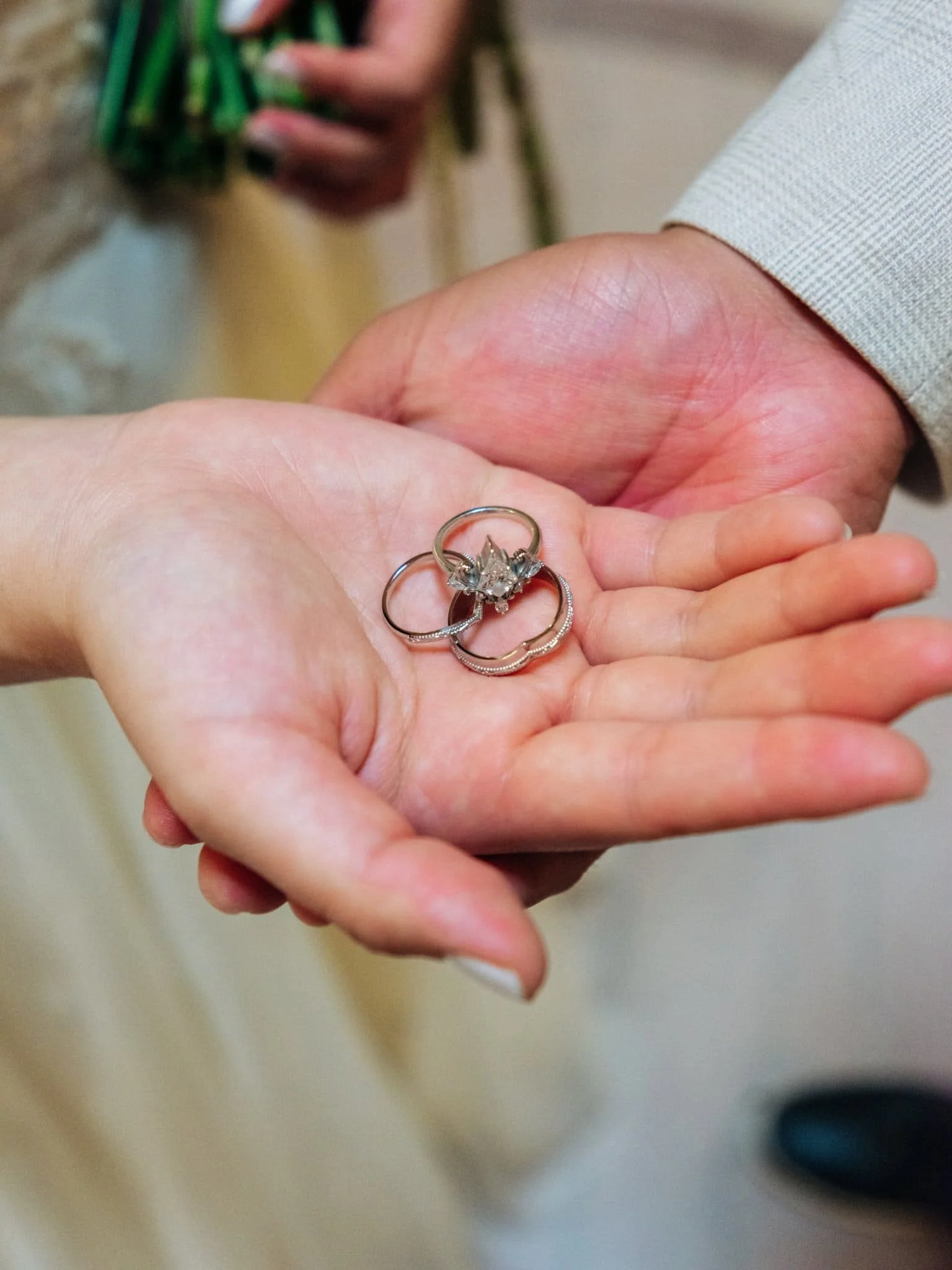 Close-up of the bride and groom’s wedding rings resting in the bride’s palm during their San Francisco City Hall elopement.