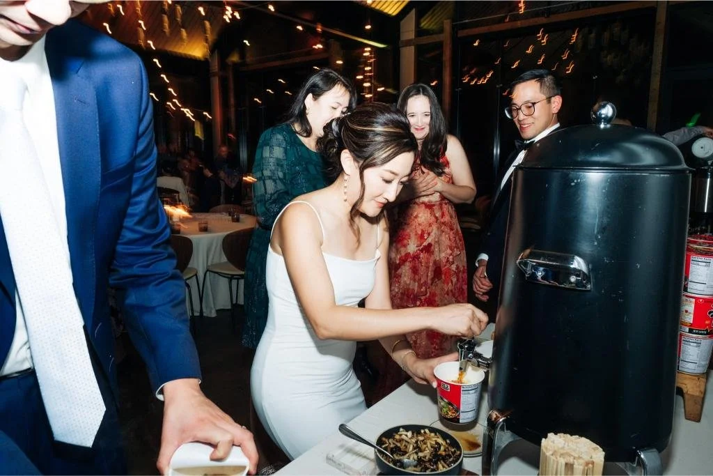 Bride preparing instant noodles at the Shin Ramyun bar during her wedding reception