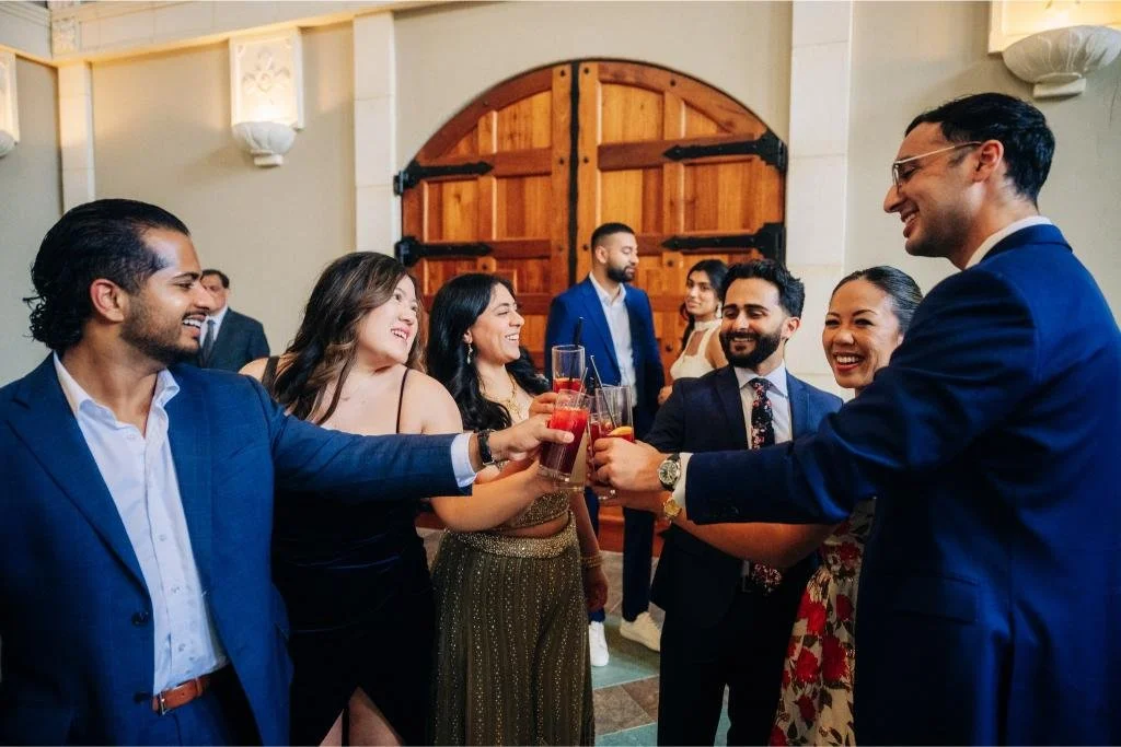 Wedding guests raising cocktails together during the reception