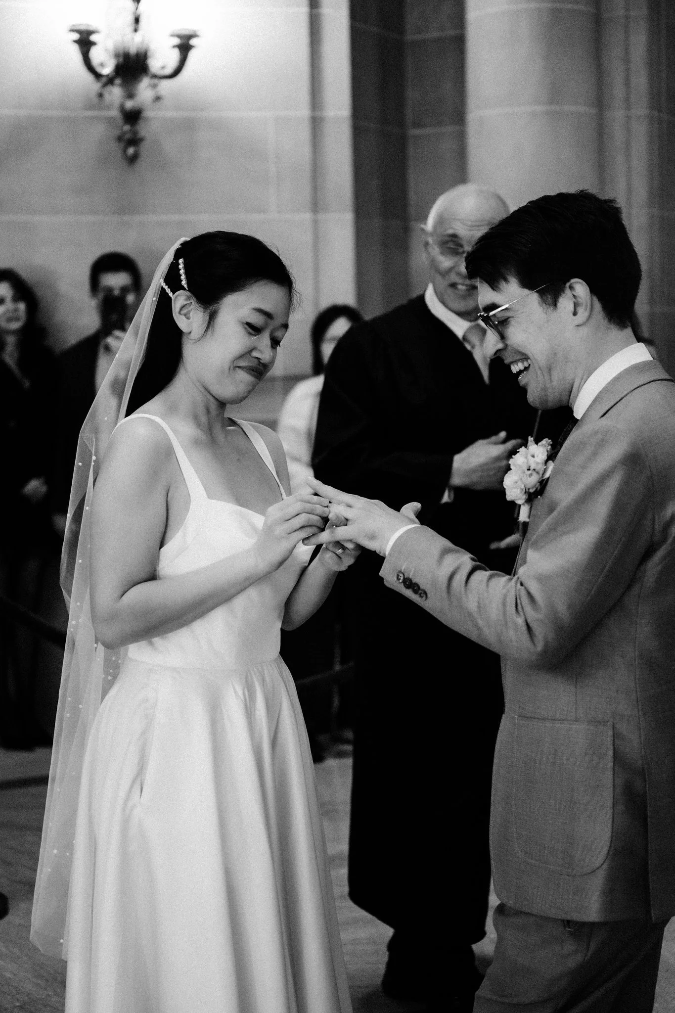 Bride putting ring on groom during San Francisco City Hall wedding ceremony