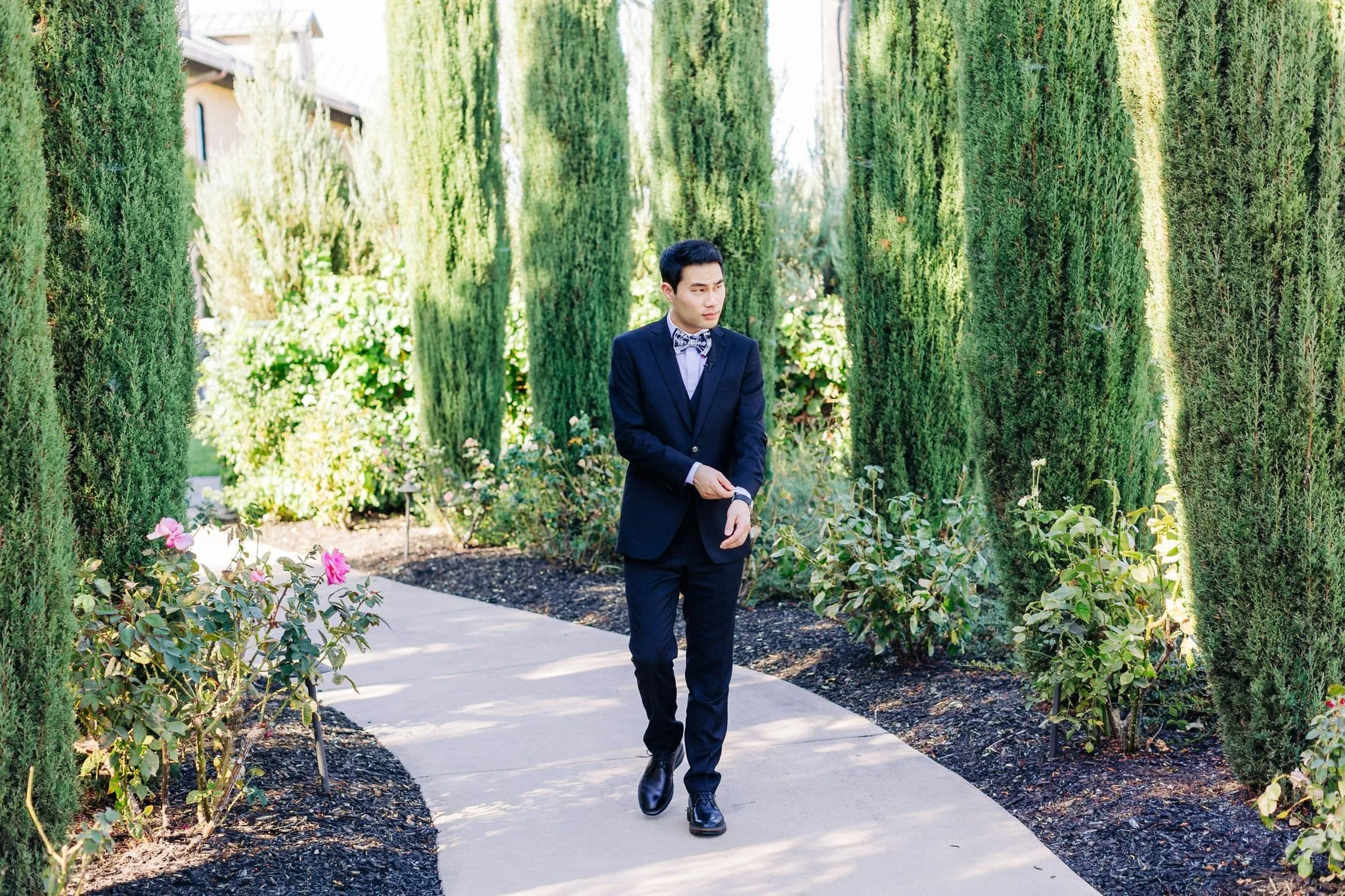groom walking down path before first look palm event center pleasanton wedding