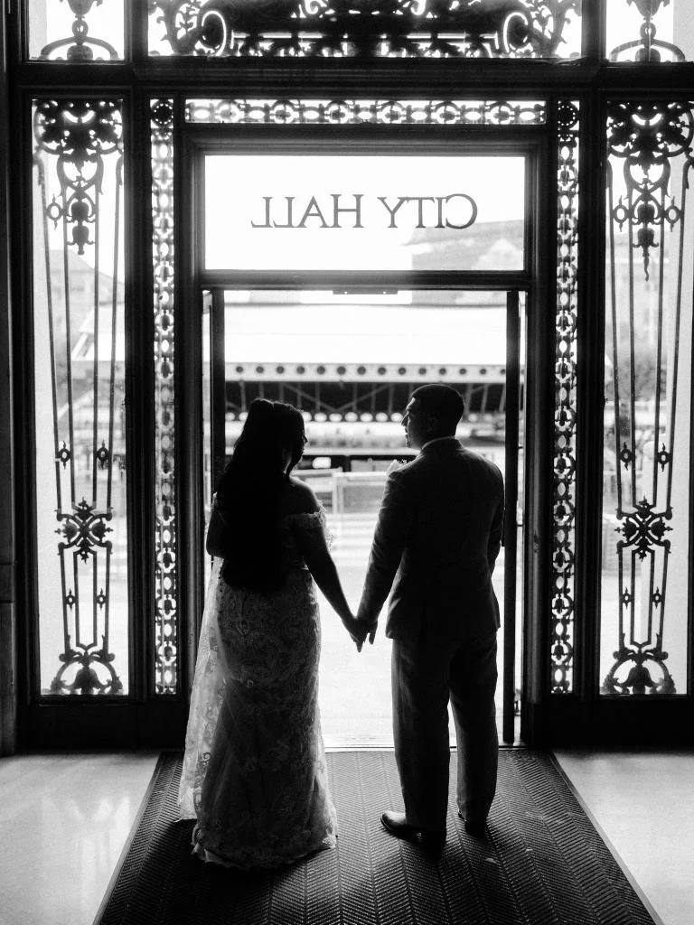 Bride and groom seen from behind just before leaving City Hall.
