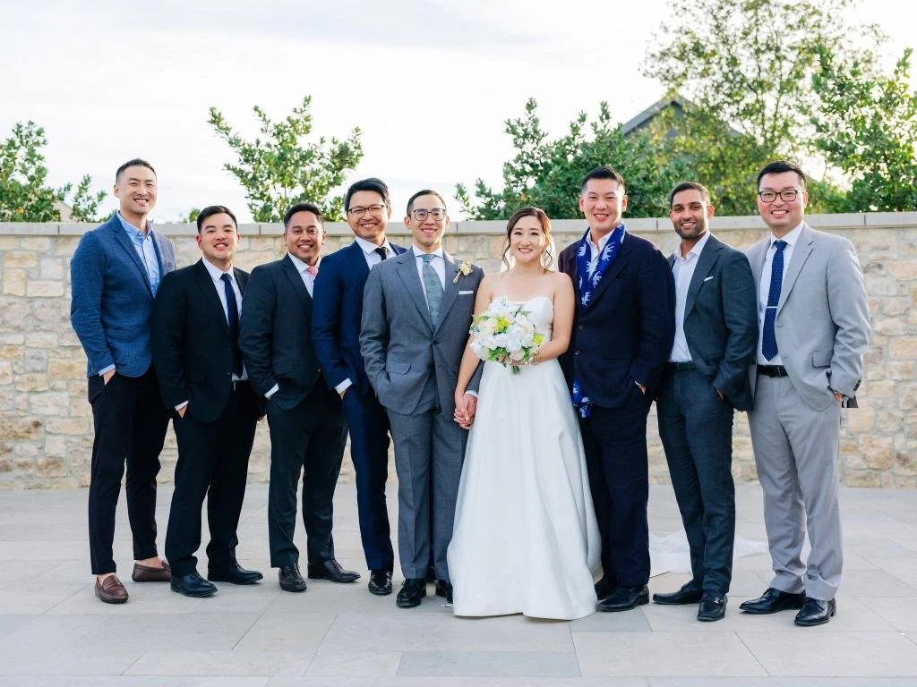 Bride and groom smiling for a group portrait with friends and family