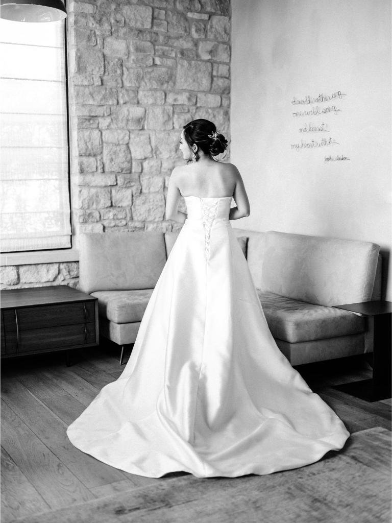 Bride photographed from behind while getting ready for her wedding